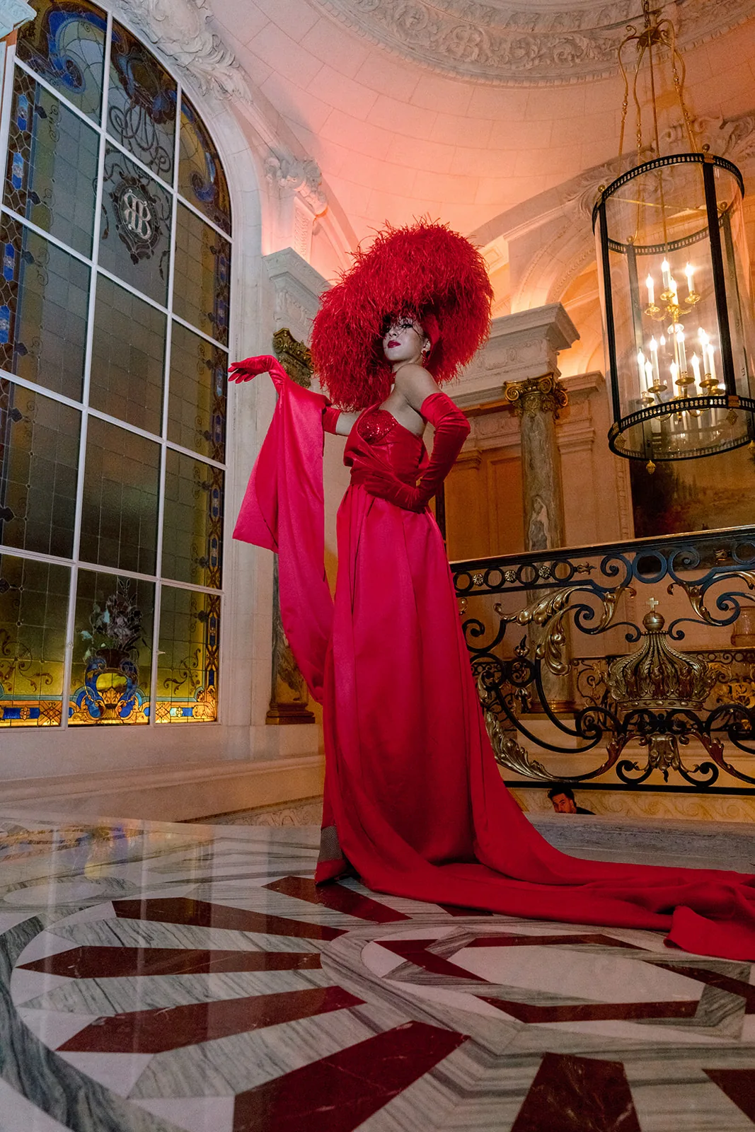 Red-costumed event entertainer posing on the grand staircase at Shangri-La Paris