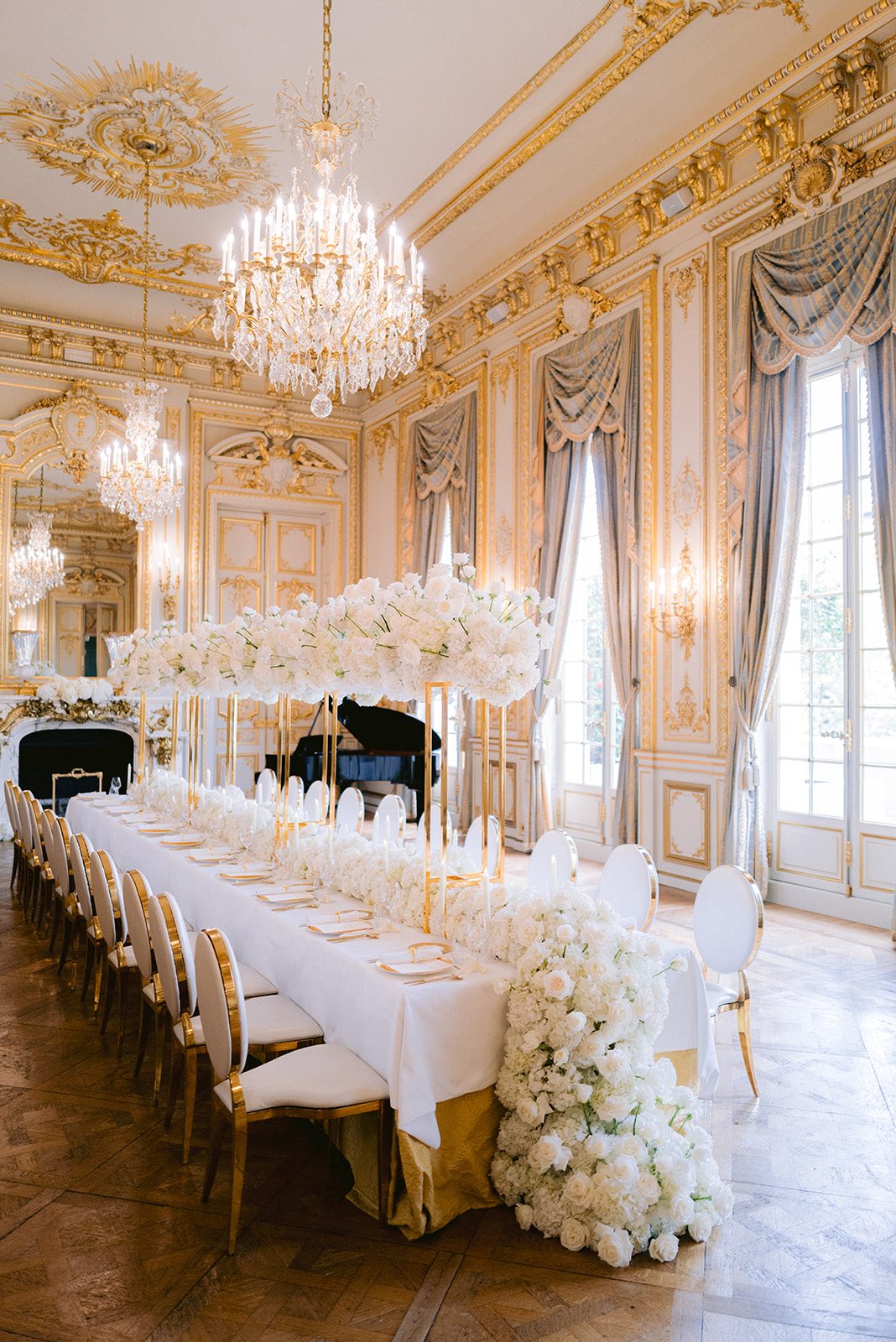 White floral wedding reception table inside an ornate Paris palace ballroom